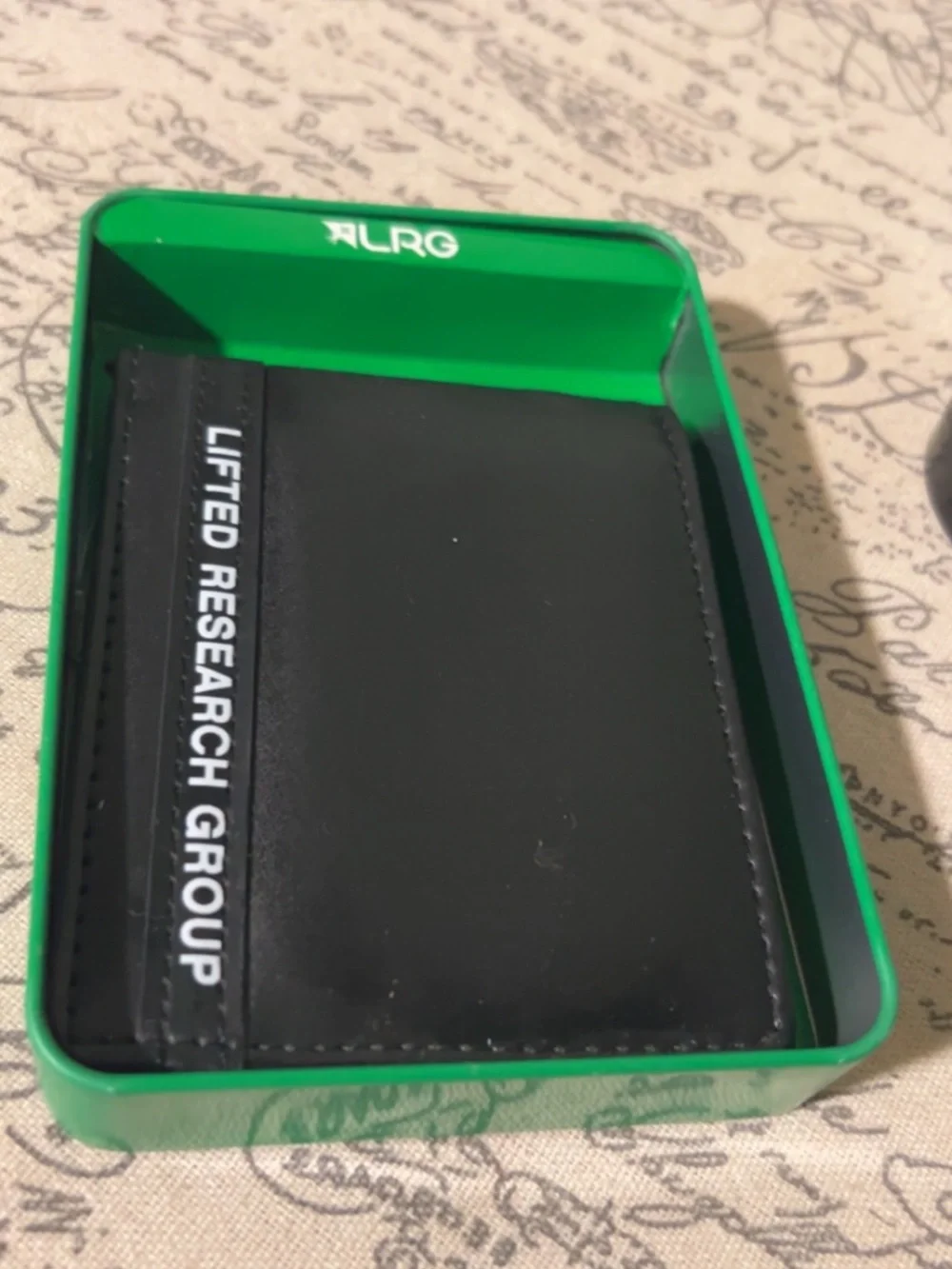 LRG Lifted Research Group black bifold wallet comes in a green branded tin